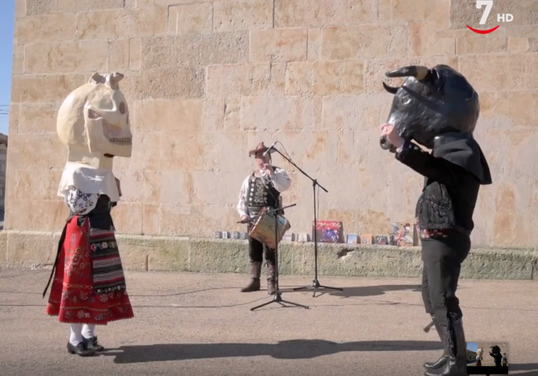 El mariquelo tocando y delante hay dos cabezudos, una de calavera y el otro de toro